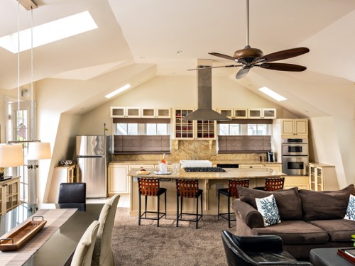 Modern open-concept kitchen and living area with skylights, a large island, and stylish furnishings.