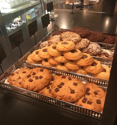 A display of assorted cookies, including chocolate chip and oatmeal, arranged in a metal tray.