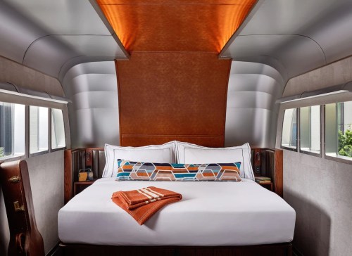 Cozy bedroom with a modern design, featuring a large bed, stylish decor, and warm wood accents.