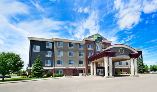 Exterior view of a modern hotel with a welcoming entrance and blue sky in the background.