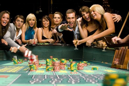 A lively casino scene with a group of people gathered around a roulette table, excitedly placing bets.