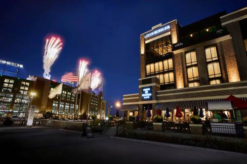 Fireworks illuminate the night sky above a stylish building, with a lively atmosphere and festive decorations.