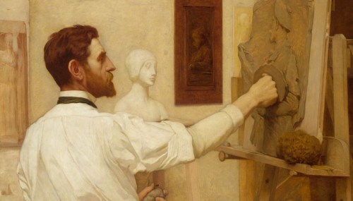 An artist sculpts a figure from clay in a studio, surrounded by sculptures and artworks.