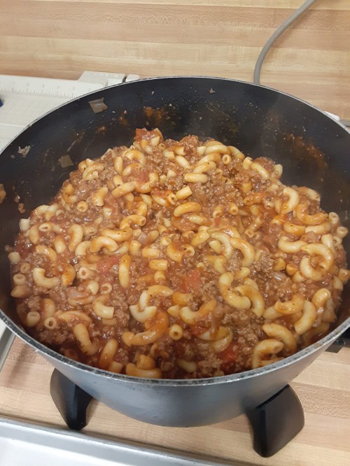 A pot of macaroni and beef in a rich tomato sauce, with elbow pasta mixed throughout.