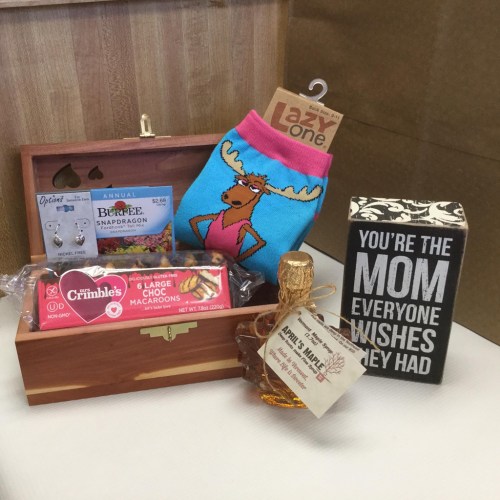 A gift box with a wooden chest, socks, macarons, and a decorative sign that says "You're the mom everyone wishes they had."