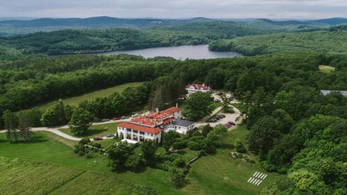 Aerial view of a large estate surrounded by lush greenery and a lake in the background.
