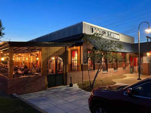 Exterior view of a restaurant at dusk, featuring outdoor seating and warm lighting.