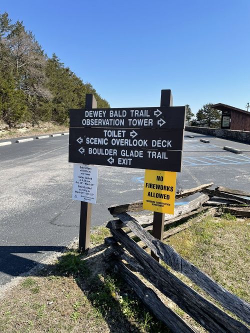 Signpost indicating directions to Dewey Bald Trail, observation tower, toilet, scenic overlook deck, and Boulder Glade Trail.