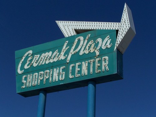 Vintage sign for Cermak Plaza Shopping Center against a clear blue sky.