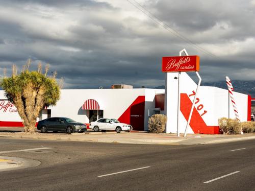 A colorful building with a sign reading "Buffet's Paradise," featuring palm trees and a cloudy sky in the background.