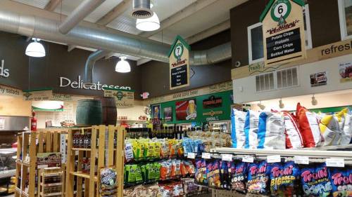 A colorful display of snacks and chips in a grocery store, with signs indicating different product sections.