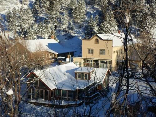 A snowy landscape featuring several houses nestled among trees on a hillside.