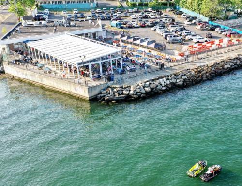 Aerial view of a waterfront area with a restaurant, parking lot, and two jet skis on the water.