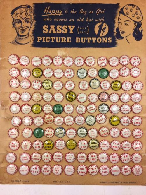 A vintage display of colorful buttons with humorous phrases, featuring a man and woman wearing hats.