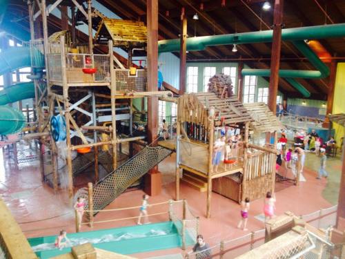 Indoor water park featuring slides, play structures, and children playing in a vibrant, spacious environment.