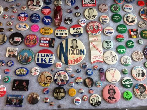 A collection of political campaign buttons featuring Nixon, Carter, and other candidates from various elections.