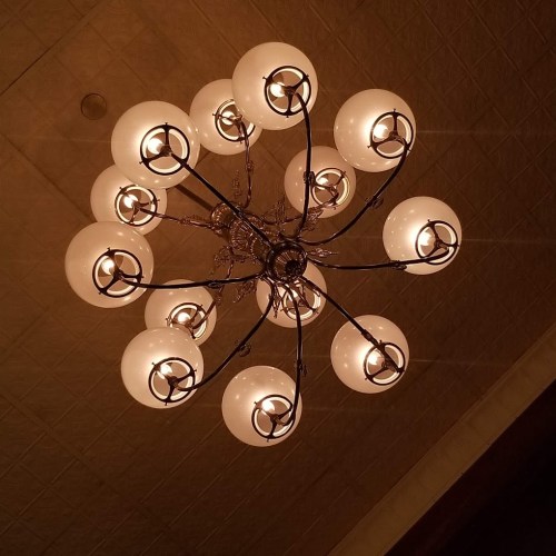 A decorative chandelier with multiple round glass bulbs hanging from a ceiling.