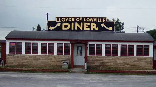 A diner with a large sign reading "Lloyds of Lowville Diner," featuring a stone facade and multiple windows.