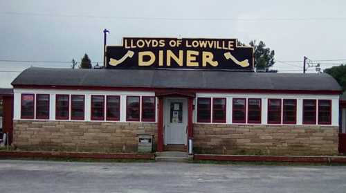 A diner with a large sign reading "Lloyds of Lowville Diner," featuring a stone facade and multiple windows.