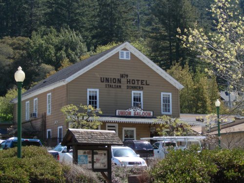 Historic Union Hotel building with "Italian Dinners" sign, surrounded by trees and parked cars.