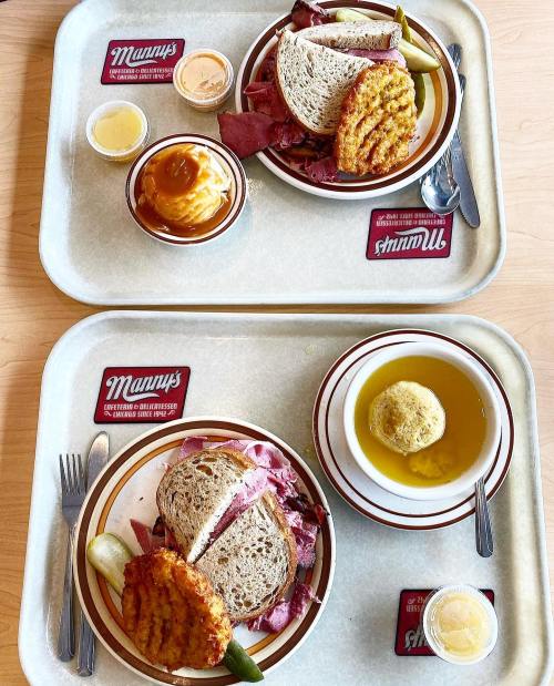 Two trays with sandwiches, pickles, potato pancakes, soup, and dipping sauces.