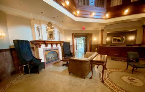 Elegant lobby with a fireplace, plush seating, and decorative lighting, featuring a warm, inviting atmosphere.