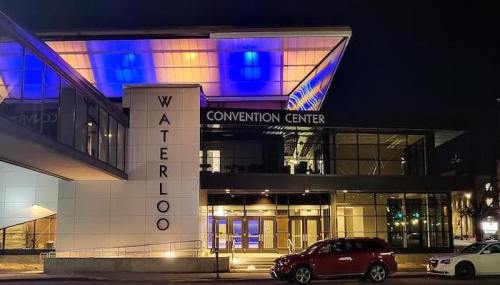 Waterloo Convention Center illuminated at night, showcasing modern architecture and vibrant lighting.