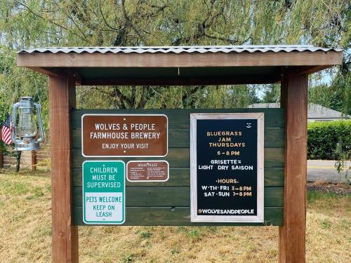 Sign for Wolves & People Farmhouse Brewery with hours, event details, and pet policy. Bluegrass Jam on Thursdays.