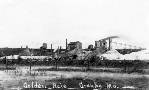 Historic black-and-white photo of the Golden Rule mine in Granby, Missouri, featuring industrial buildings and equipment.