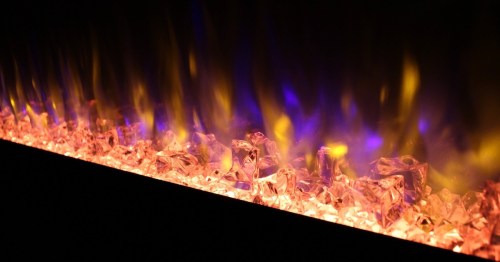 A close-up of a modern electric fireplace with glowing crystals and vibrant flames in shades of orange and blue.