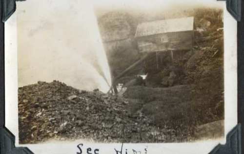 Black and white photo of a mining site with a wooden structure and piles of rocks. Text at the bottom reads "Sec Mine."