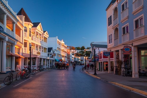 A quiet street lined with colorful buildings and bicycles, illuminated by the warm glow of sunset.