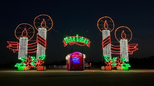 Colorful holiday lights display featuring three large candles and a festive sign that reads "Lite Lites."