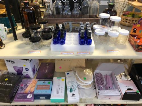 A display of various glass jars, bottles, and beauty products on a shelf, with colorful price tags.