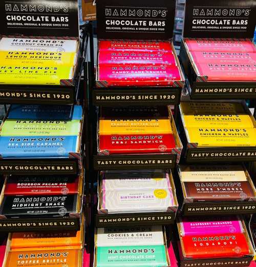 A colorful display of Hammond's chocolate bars in various flavors, neatly arranged on shelves.