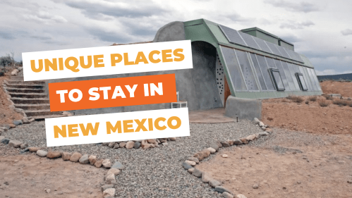 A modern, eco-friendly house with solar panels, surrounded by gravel and desert landscape, promoting unique stays in New Mexico.