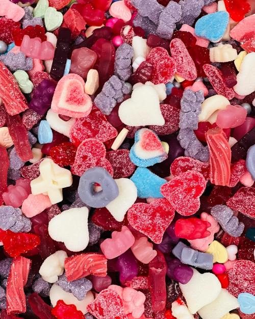 A colorful assortment of various gummy candies, including hearts, bears, and other shapes in vibrant hues.