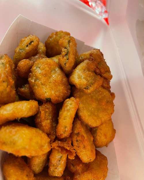 A close-up of a container filled with golden-brown, crispy fried snacks.