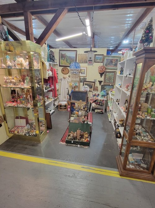 A vintage shop interior filled with various collectibles, displays, and decorations in a cozy, cluttered setting.