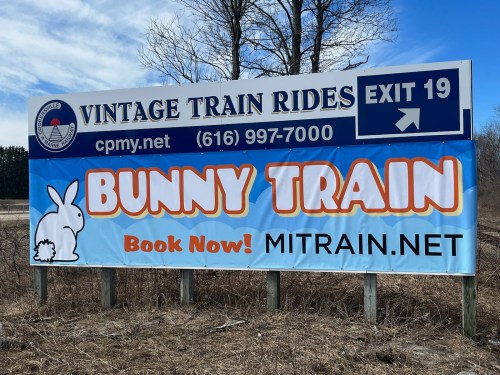 Sign for vintage train rides featuring "Bunny Train" with a rabbit graphic. Includes contact info and website links.