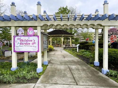 A colorful entrance to the Children's Garden, featuring a gazebo and playful signage for curious kids.