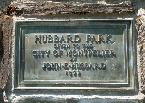 Plaque reading "Hubbard Park given to the City of Montpelier by John E. Hubbard 1899" mounted on a stone wall.