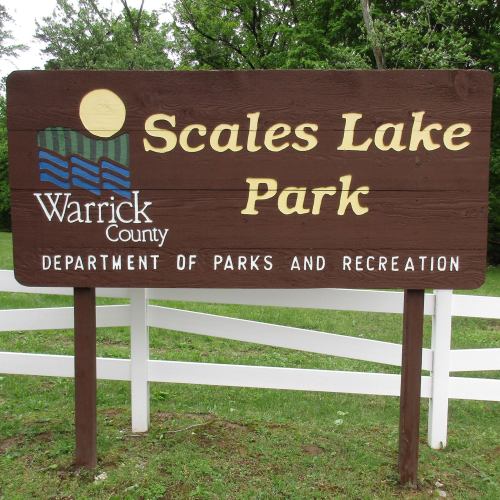 Sign for Scales Lake Park in Warrick County, featuring a blue and green design with trees and water.