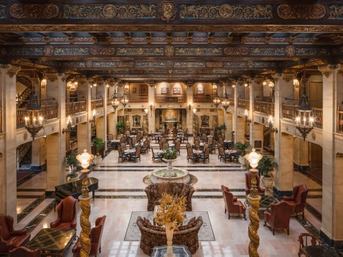 Luxurious hotel lobby with ornate decor, elegant seating, and grand chandeliers, showcasing a sophisticated atmosphere.