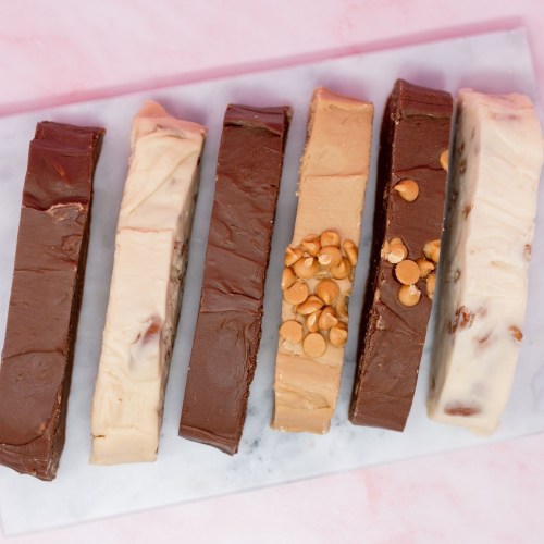 A variety of fudge bars in different flavors, arranged neatly on a marble surface.