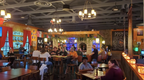 A cozy restaurant interior with patrons dining, warm lighting, and decorative elements creating a welcoming atmosphere.