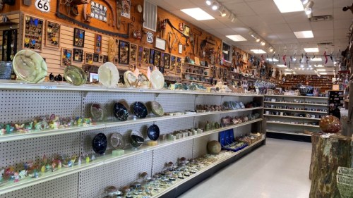 A colorful gift shop interior with shelves displaying various decorative items and souvenirs along the walls.