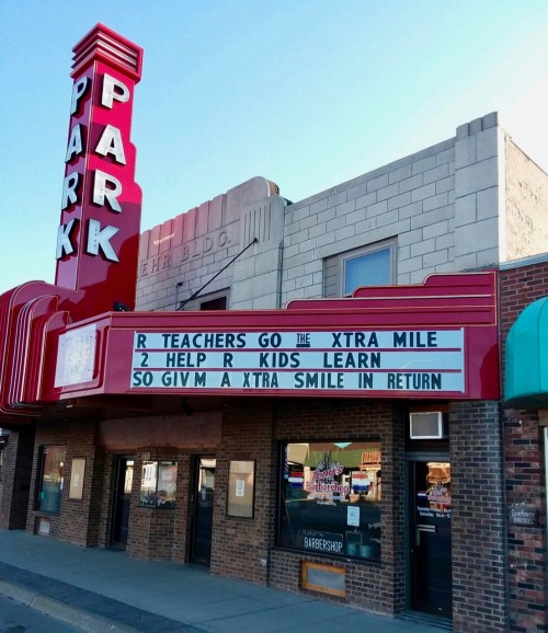 Sign outside a theater reads: "R teachers go the xtra mile 2 help R kids learn, so givm a xtra smile in return."