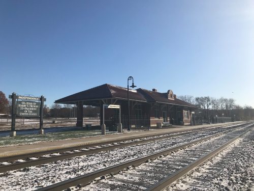 Historic train station in Independence, with snow-covered tracks and clear blue sky.