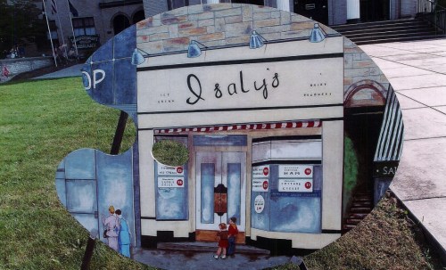 A colorful artist's palette cutout featuring a vintage ice cream shop facade with children outside.